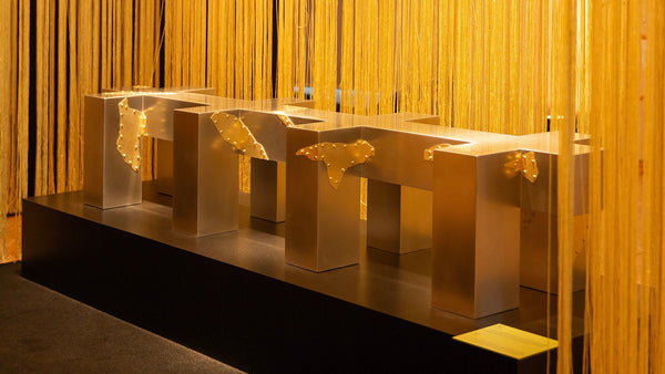 Artwork by MILLIM STUDIO: OMNES - "Steel and brass intertwine in a sculptural bench where a golden seam unites diverse identities in an invitation to connect."